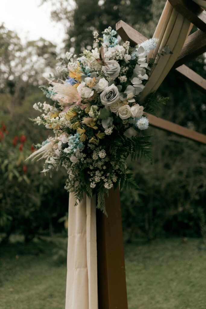 White wedding flower decoration with white drapes, part of the wide rustic wedding decoration