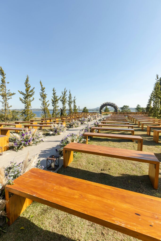 A rustic wedding setting with minimal floral decoration, sleek wooden benches